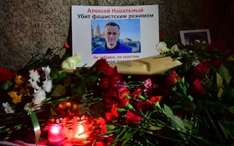 Flowers lay next to a picture of late Russian opposition leader Alexei Navalny at a makeshift memorial organized at the monument to the victims of political repressions in Saint Petersburg on February 16, 2024, following Navalny's death in his Arctic prison. (Photo by Olga MALTSEVA / AFP)