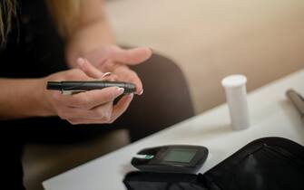 Diabetic young women performing a glucose level blood test at home