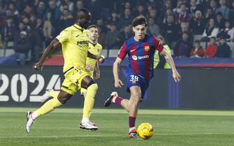 epa11108901 Villarreal's Eric Bailly (L) and FC Barcelona's Hector Fort (R) in action during the Spanish LaLiga soccer match between FC Barcelona and Villarreal CF, in Barcelona, Spain, 27 January 2024.  EPA/Toni Albir
