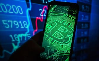 POLAND - 2023/03/21: In this photo illustration, a Bitcoin logo is displayed on a smartphone with stock market percentages in the background. (Photo Illustration by Omar Marques/SOPA Images/LightRocket via Getty Images)