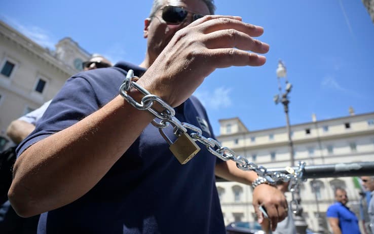 Un gruppo di tassisti incatenati alle transenne di palazzo Chigi in piazza Colonna per chiedere un incontro con il presidente del Consiglio ,Mario Draghi. Roma, 12 luglio 2022. ANSA/CLAUDIO PERI