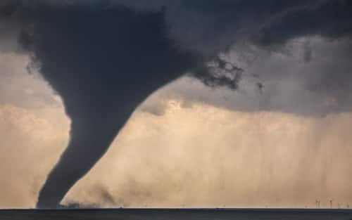 A tornado descends from a supercell near Dodge City, Kansas, May 24, 2016.  Wind generators are in the background.