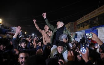 People celebrate along a street in Khan Yunis in the southern Gaza Strip on January 15, 2025, amid the ongoing war in the Palestinian territory between Israel and Hamas. Thousands of Gazans celebrated on January 15 as news spread that a ceasefire and hostage release deal had been reached between Israel and Hamas, aimed at ending more than 15 months of war in the Palestinian territory. (Photo by BASHAR TALEB / AFP)