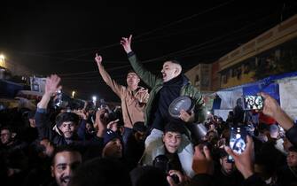 Persone festeggiano in strada a Gaza per l'accordo fra Israele e Hamas People celebrate along a street in Khan Yunis in the southern Gaza Strip on January 15, 2025, amid the ongoing war in the Palestinian territory between Israel and Hamas. Thousands of Gazans celebrated on January 15 as news spread that a ceasefire and hostage release deal had been reached between Israel and Hamas, aimed at ending more than 15 months of war in the Palestinian territory. (Photo by BASHAR TALEB / AFP)