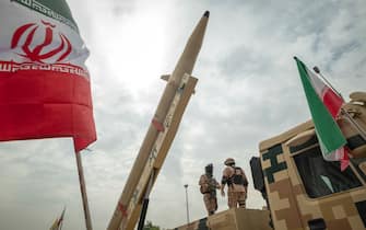Two Islamic Revolutionary Guard Corps (IRGC) military personnel stand guard under an Iranian Kheibar Shekan Ballistic missile in downtown Tehran during a rally commemorating the International Quds Day, also known as the Jerusalem day, on April 29, 2022. (Photo by Morteza Nikoubazl/NurPhoto via Getty Images)