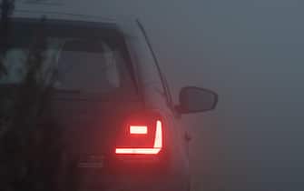 Tail lights of a car in thick fog, blue hour, foggy evening, foggy night, fog, car