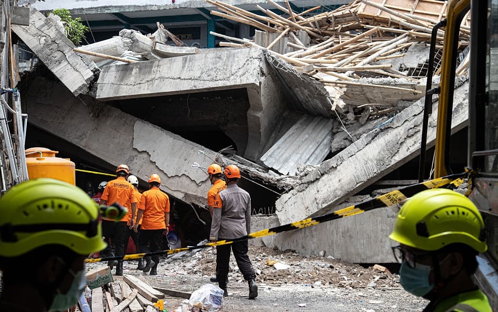 SIDOARJO, EAST JAVA, INDONESIA - OCTOBER 01: Indonesia National Search and Rescue Agency officers search for survivors in the rubble of the collapsed Islamic Boarding School Al Khoziny building on October 01, 2025 in Sidoarjo, East Java, Indonesia. The Islamic Boarding School Al Khoziny Buduran Sidoarjo collapsed trapping dozens of students while performing Asr prayers. Indonesia National Search and Rescue Agency reported that four students died and 98 others suffered minor to serious injuries and were referred to Siti Hajar Islamic Hospital and Sidoarjo Regional Hospital. Search and evacuation efforts for buried victims are still being carried out. (Photo by Robertus Pudyanto/Getty Images)