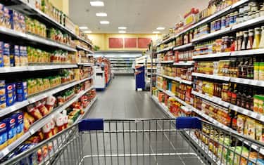 An empty cart between shelves in the supermarket.