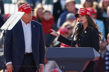 (L-R) Former US President and Republican presidential candidate Donald Trump listens as North Dakota Governor Kristi Noem speaks during a Buckeye Values PAC Rally in Vandalia, Ohio, on March 16, 2024. (Photo by KAMIL KRZACZYNSKI / AFP) (Photo by KAMIL KRZACZYNSKI/AFP via Getty Images)