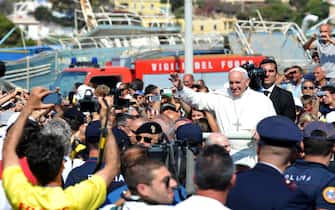 A Lampedusa LAMPEDUSA, ITALY - JULY 08: Pope Francis waves to the faithful as he arrives in the island on July 8, 2013 in Lampedusa, Italy. On his first official trip outside Rome, Pope Francis arrived at Lampedusa airport and then boarded a boat accompanied by fishermen in their own boats to lay a wreath in the sea in memory of those who lost their lives in the crossing. The Pope also met with a group of immigrants at the pier and celebrated mass. (Photo by Tullio M. Puglia/Getty Images)