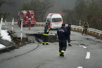 epa11054315 Rescue workers survey a damaged road in Noto Peninsula, Ishikawa Prefecture, Japan, 03 January 2024. At least 62 people were killed by the magnitude 7 earthquake (the USGS listed the magnitude as 7.5) which occurred on 01 January, according to the Ishikawa Prefecture Government.  EPA/FRANCK ROBICHON