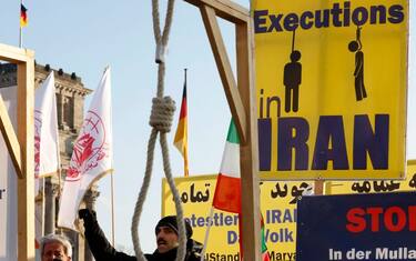 Activists of the Exile-Iranian Society hold placards and gallows as they demonstrate in solidarity with anti-government protesters in their home country, on January 19, 2023 in front of the Reichstag building that houses the Bundestag (lower house of parliement) in Berlin, calling Germany and the European Union to blacklist the Islamic Revolutionary Guard Corps as a terrorist group. - Iran has been rocked by demonstrations over the September 16 death in custody of Mahsa Amini, a 22-year-old Iranian Kurd who had been arrested for an alleged breach of the country's dress code for women. Authorities have made thousands of arrests amid a bloody crackdown that has claimed hundreds of lives, and have executed four people in connection with the civil unrest. (Photo by Odd ANDERSEN / AFP) (Photo by ODD ANDERSEN/AFP via Getty Images)