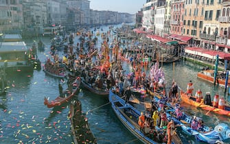 VENICE, ITALY - JANUARY 28: Boats carrying people dressed in masks transit the Grand Canal near the Rialto Bridge during the Carnival Regatta on Jan. 28, 2024 in Venice, Italy. The Venice Carnival began on Jan. 27 and will end on Feb. 13, 2024, and will be titled "To the East, the wondrous voyage of Marco Polo." (Photo by Stefano Mazzola/Getty Images)