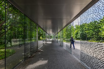 2157270950 Basel, Switzerland - 04 June 2024: The glass corridor to the entrance of Novartis Campus in Basel. Novartis is an renown international pharmaceutical industrial company.