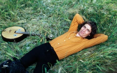 Singer-songwriter Rino Gaetano lying on grass next to a chordophone musical instrument. Italy, 1978 (Photo by Angelo Deligio\Mondadori Portfolio\Mondadori via Getty Images)