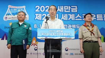 epa10784327 South Korea's Prime Minister Han Duck-soo (C) announces safety measures for the attendees of the World Scout Jamboree at the event's venue in the Saemangeum reclamation area in Buan, North Jeolla Province, on South Korea's west coast, 04 August 2023. Interior Minister Lee Sang-min (L) and Culture Minister Park Bo-gyoon also attended the news conference.  EPA/YONHAP SOUTH KOREA OUT