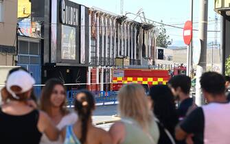 Emergency services cordon off a street where at least thirteen people were killed in a fire at a nightclub in Murcia, on October 1, 2023. At least 13 people were killed in a fire in a Spanish nightclub today morning, authorities said, with fears the toll could still rise as rescue workers sift through the debris. The fire appears to have broken out in a building housing the "Teatre" and "Fonda Milagros" clubs in the city of Murcia in southeastern Spain in the early morning hours. (Photo by JOSE JORDAN / AFP) (Photo by JOSE JORDAN/AFP via Getty Images)