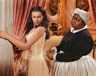 Vivien Leigh (1913-1967), British actress, has her corset tightened by Hattie McDaniel (1892Â 1952), US actress, in a publicity still issued for the film, 'Gone with the Wind', 1939. The drama, directed by Victor Fleming (1889-1949), starred Leigh as 'Scarlett O'Hara', and McDaniel as 'Mammy'. (Photo by Silver Screen Collection/Getty Images)