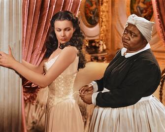 Vivien Leigh (1913-1967), British actress, has her corset tightened by Hattie McDaniel (1892Â 1952), US actress, in a publicity still issued for the film, 'Gone with the Wind', 1939. The drama, directed by Victor Fleming (1889-1949), starred Leigh as 'Scarlett O'Hara', and McDaniel as 'Mammy'. (Photo by Silver Screen Collection/Getty Images)