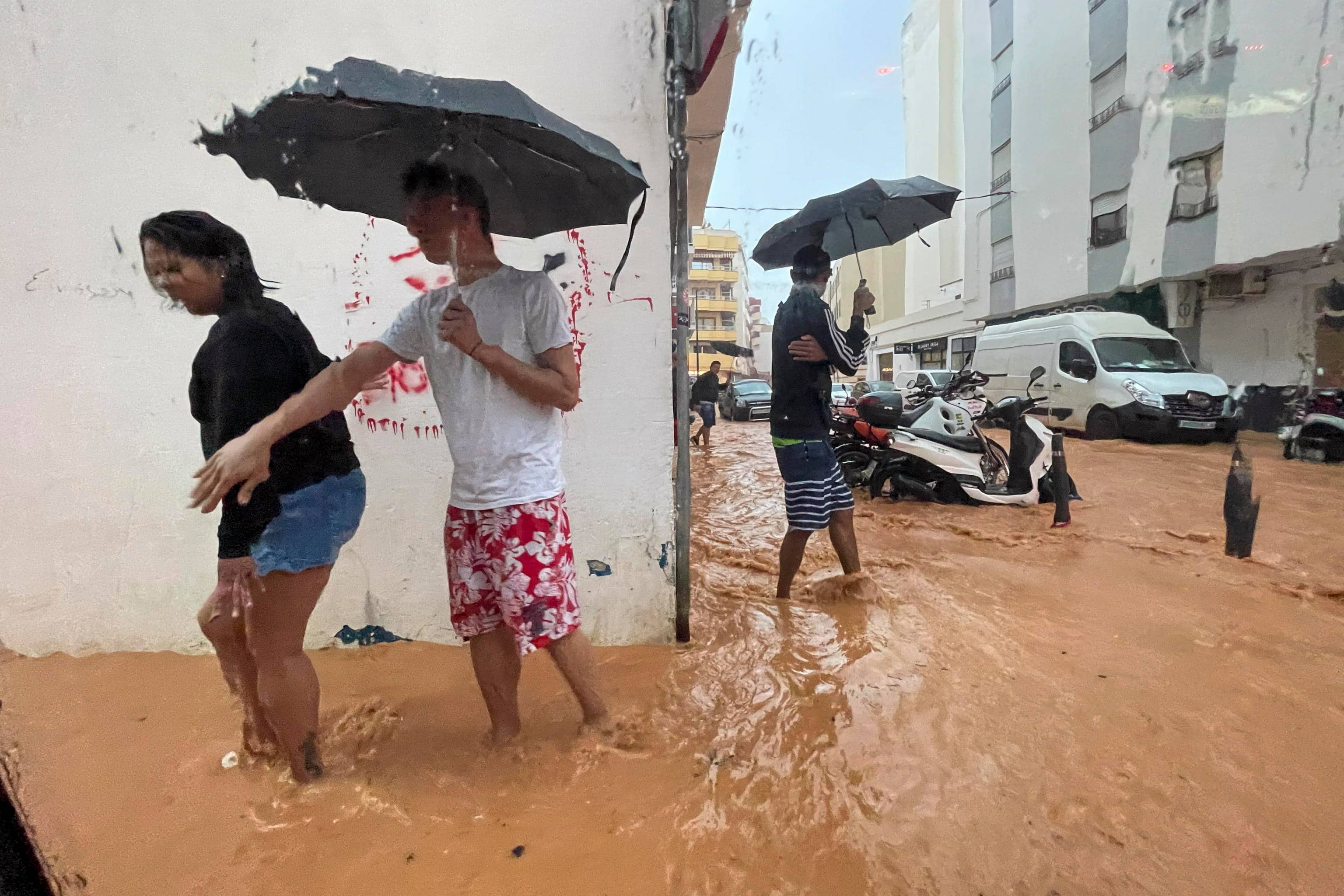 epa12416591 People walk along flooded streets in Ibiza, Spain, 30 September 2025, after heavy rains that have caused several floods throughout the island. Spain's State Meteorological Agency (Aemet) issued red, orange and yellow alerts for heavy rains affecting several regions across the country.  EPA/Sergio G. Canizares