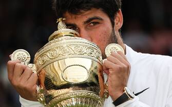 Spain's Carlos Alcaraz kisses the winner's trophy after beating Serbia's Novak Djokovic during their men's singles final tennis match on the last day of the 2023 Wimbledon Championships at The All England Tennis Club in Wimbledon, southwest London, on July 16, 2023. (Photo by Adrian DENNIS / AFP) / RESTRICTED TO EDITORIAL USE (Photo by ADRIAN DENNIS/AFP via Getty Images)