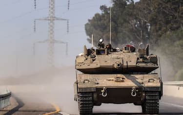 An Israeli tank rolls on a highway near the southern city of Sderot on October 8, 2023. Israel's prime minister of October 8 warned of a "long and difficult" war, as fighting with Hamas left hundreds killed on both sides after a surprise attack on Israel by the Palestinian militant group. (Photo by RONALDO SCHEMIDT / AFP) (Photo by RONALDO SCHEMIDT/AFP via Getty Images)