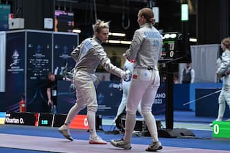 Ukraine's Olga Kharlan (L) gestures towards Russia's Anna Smirnova, registered as an Individual Neutral Athlete (AIN), prior to competing during the Sabre Women's Senior Individual qualifiers, as part of the FIE Fencing World Championships at the Fair Allianz MI.CO (Milano Convegni) in Milan, on July 27, 2023. (Photo by Andreas SOLARO / AFP)