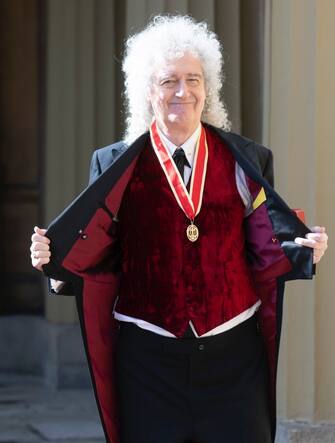 Brian May dopo la cerimonia di cavalierato mostra la medaglia