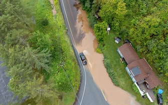 LONDONDERRY, VERMONT - JULY 10: In an aerial view, a pick-up truck drives along a flooded road after heavy rain on July 10, 2023 in Londonderry, Vermont. Torrential rain and flooding has affected millions of people from Vermont south to North Carolina. (Photo by Scott Eisen/Getty Images)