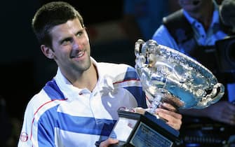epa02557266 Novak Djokovic of Serbia hold his trophy after winning against Andy Murray of Great Britain during their men's singles final round match at the Australian Open Grand Slam tennis tournament in Melbourne, Australia, 30  January 2011.  EPA/BARBARA WALTON