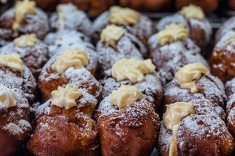 Pancakes (Frittelle)  filled  with eggnog (zabaglione) cream, Typical dessert of Italian cuisine, handmade and for sale in the days of celebration (Christmas, New Year, Carnival, Easter, etc.) in markets and shops of all cities. Here is Venice