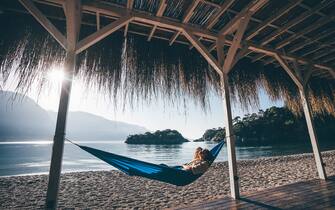 Woman relaxing in hammock on beach