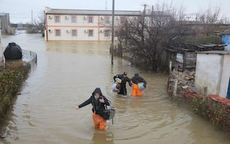 Local residents are seen evacuated from the flooded village of Pribrezhnoe in Crimea on November 27, 2023, following a storm. Over 400,000 people in Crimea were left without power on November 27, 2023 after hurricane force winds and heavy rains battered the Russian-annexed peninsula over the weekend. Wind speeds of more than 140 kilometres per hour (about 90 mph) were recorded during the storm, which triggered a state of emergency in some of the peninsula's municipalities. (Photo by STRINGER / AFP)