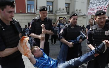 Police officers detain Nikolai Alexeyev (C), an activist of the LGBT (lesbian, gay, bisexual, and transgender) community, who was trying to participate in a parade in front of the Moscow's mayor office building in Moscow, Russia, 30 May 2015. ANSA/SERGEI ILNITSKY