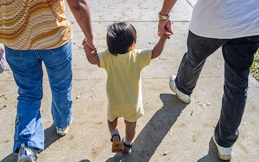 Miami Florida,Chinese New Year Festival,Asian girl child holds parents hand hands,
