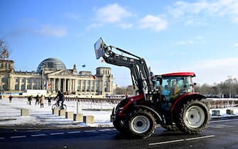 Farmers with their tractors drive near the Reichstag building during a protest under the title 'We are fed up with agricultural industry' against industrial food production in Berlin, Germany on January 20, 2024. The demonstration started on January 20 in front of the headquarters of German Social Democratic Party SPD and ended with a rally in front of the Chancellery. (Photo by Tobias SCHWARZ / AFP)