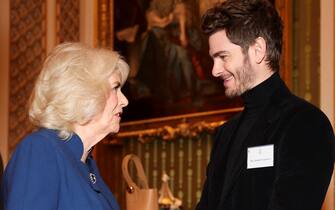 LONDON, ENGLAND - FEBRUARY 18: British Queen Camilla speaks to actor Andrew Garfield, on the day she attends a reception for staff, actors and supporters of the National Theatre at Buckingham Palace on February 18, 2025 in London, England. (Photo by Isabel Infantes - WPA Pool/Getty Images)