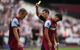 epa10864674 West Ham United's Lucas Paqueta is shown a yellow card by referee Andrew Madley during the English Premier League match between West Ham United and Manchester City in London, Britain, 16 September 2023.  EPA/DANIEL HAMBURY EDITORIAL USE ONLY. No use with unauthorized audio, video, data, fixture lists, club/league logos or 'live' services. Online in-match use limited to 120 images, no video emulation. No use in betting, games or single club/league/player publications