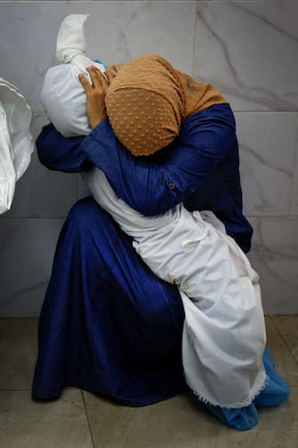 Palestinian woman Inas Abu Maamar, 36, embraces the body of her 5-year-old niece Saly, who was killed in an Israeli strike, at Nasser hospital in Khan Younis in the southern Gaza Strip, October 17, 2023. REUTERS/Mohammed Salem 