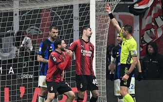 Referee Andrea Colombo (R) shows a red card to AC Milan's Italian defender #02 Davide Calabria (2nd-L) during the Italian Serie A football match between AC Milan and Inter Milan at the San Siro Stadium in Milan on April 22, 2024. (Photo by GABRIEL BOUYS / AFP) (Photo by GABRIEL BOUYS/AFP via Getty Images)