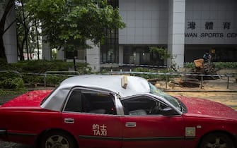 A taxi damaged by a fallen tree following Super Typhoon Saola in Hong Kong, China, on Saturday, Sept. 2, 2023. Severe Typhoon Saola began to weaken and gradually depart Hong Kong, after bringing hurricane-force winds and heavy rain to the territory. Photographer: Justin Chin/Bloomberg via Getty Images