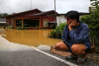 epa10501878 A man looks at the flood near his relative's house in Yong Peng, Johor, Malaysia, 04 March 2023. According to state media, more than 33,000 people were evacuated in four states affected by the floods.  EPA/FAZRY ISMAIL