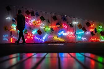 A visitor walks past "Topa" a 2005 neon installation by US artist Jason Rhoades, displayed at the Unlimited section of the Art Basel fair for Modern and contemporary art, in Basel, Switzerland on June 13, 2023. The fair will open to the public from June 15 to June 18, 2023 and features over 200 leading galleries and more than 4,000 artists from five continents. (Photo by FABRICE COFFRINI / AFP) / RESTRICTED TO EDITORIAL USE - MANDATORY MENTION OF THE ARTIST UPON PUBLICATION - TO ILLUSTRATE THE EVENT AS SPECIFIED IN THE CAPTION (Photo by FABRICE COFFRINI/AFP via Getty Images)