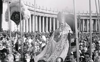 (Original Caption) Pope John XXIII blesses crowd from Gestatorial chair as he is carried through St. Peter's Square here, October 11th. Nearly 3,000 Catholic church leaders are meeting in the Ecumenical Council here.