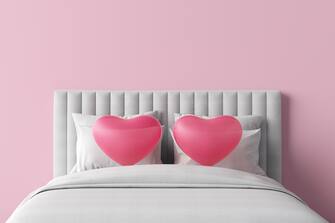 bed soft pillows headboard love hearts pink white sheets furniture sleep relax couple cuddle frame mattress quilt duvet bedding shape. Sweet valentine festival marriage and sex. 3D Illustration.