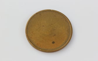 This image captures the unique and historical design of a token from the Newark College of Engineering, now known as the New Jersey Institute of Technology. The reverse side of the token is empty. The origins and purpose of this token is still unknown, but it was identified as similar to a token found for sale on ebay with the initials "N.J.I.T." on the reverse side, unlike the one pictured here. The mysterious looking token was found by the photographer and the story of how it was identified is a personal quest, involving asking coin graders, people on Quora and even tweeting to the New Jersey Institute of Technology.
