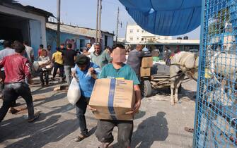 Palestinians storm a UN-run aid supply center, that distributes food to displaced families following Israel's call for more than one million residents in northern Gaza to move south for their safety, in Deir al-Balah on October 28, 2023, amid the ongoing battles between Israel and the Palestinian group Hamas. Thousands of civilians, both Palestinians and Israelis, have died since October 7, 2023, after Palestinian Hamas militants based in the Gaza Strip entered southern Israel in an unprecedented attack triggering a war declared by Israel on Hamas with retaliatory bombings on Gaza. (Photo by MOHAMMED ABED / AFP) / "The erroneous mention[s] appearing in the metadata of this photo by MOHAMMED ABED has been modified in AFP systems in the following manner: [Storm] instead of [Collect boxes and and bags from]. Please immediately remove the erroneous mention[s] from all your online services and delete it (them) from your servers. If you have been authorized by AFP to distribute it (them) to third parties, please ensure that the same actions are carried out by them. Failure to promptly comply with these instructions will entail liability on your part for any continued or post notification usage. Therefore we thank you very much for all your attention and prompt action. We are sorry for the inconvenience this notification may cause and remain at your disposal for any further information you may require." (Photo by MOHAMMED ABED/AFP via Getty Images)