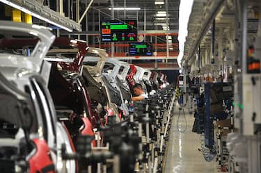 Employees work on the assembly of new Fiat 500L automobiles on the production line at the Fiat Automobili Srbija plant in Kragujevac, Serbia, on Wednesday, March 20, 2013. Fiat Automobili Srbija, a joint venture between the government and Italian carmaker Fiat, is Serbia's sole automaker. Photographer: Oliver Bunic/Bloomberg via Getty Images