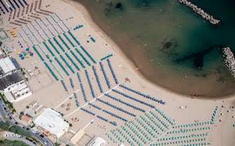 TERMOLI, ITALY - JULY 03: Aerial view, from a helicopter, of the beach with coloured umbrellas in Termoli. The city is located in the province of Campobasso in the Molise region. Located along the Adriatic coast, it is the only port in Molise. It is also a fishing, tourist and industrial centre. The town retains the medieval village enclosed within the walls that separate it from the modern city on July 03, 2019 in Termoli, Italy. Italy's nearly 8000 km (5,000 miles) coastlines and islands stretch across the Mediterranean Sea and attract large numbers of both local and foreign tourists during the summer season. (Photo by Fabrizio Villa/Getty Images)