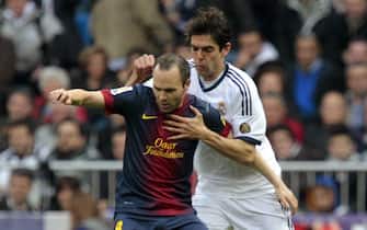 epa03607132 FC Barcelona's midfielder Andres Iniesta (L) fights for the ball with Brazilian midfielder Ricardo Izecson 'Kaka' (R) of Real Madrid during their Primera Division match played at Santiago Bernabeu stadium in Madrid, Spain on 02 March 2013.  EPA/Alberto Martin